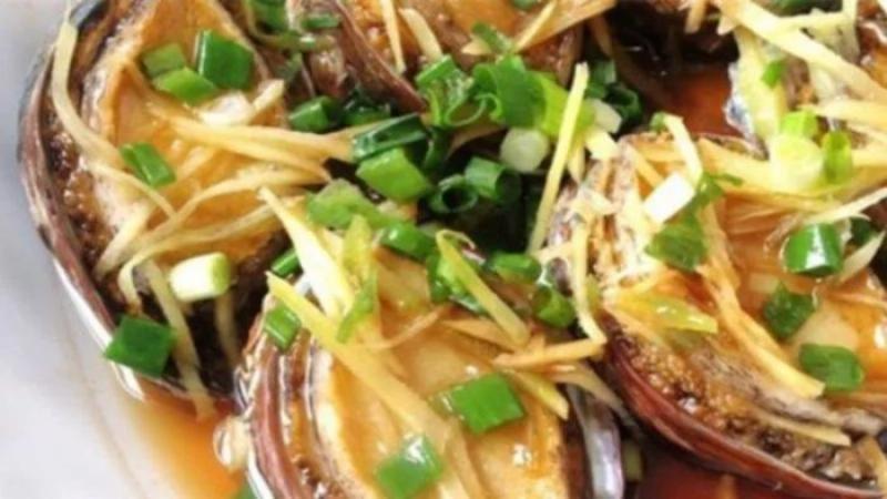 Đĩa bào ngư hấp gừng thơm ngon, trang trí với hành lá và gừng sợi, thể hiện món ăn thanh đạm hấp dẫn
